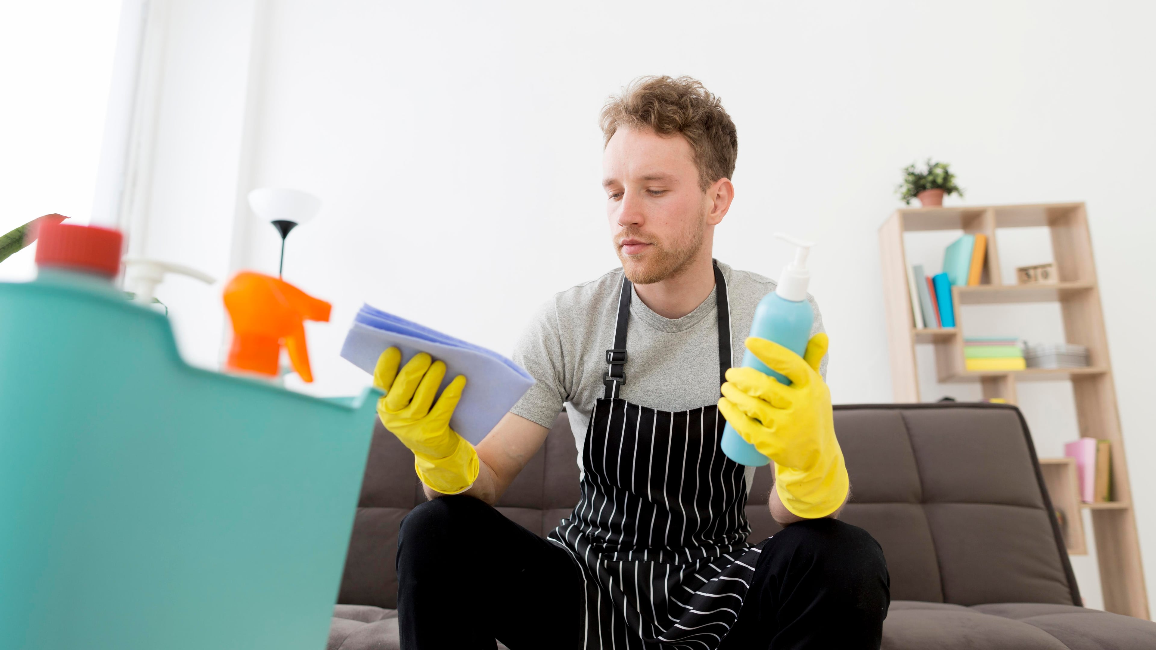 Schoonmaker met schoonmaakmiddelen voor woning reiniging
